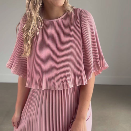 A pleated blush maxi dress with a blouson top and a-line skirt.