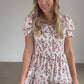 A smocked floral short sleeve midi dress with a round neckline, and tiered skirt.