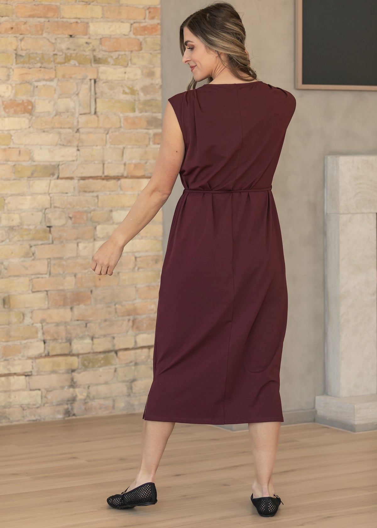Back of mulberry self-tie dress showing its round neckline, center seam, and midi hem.