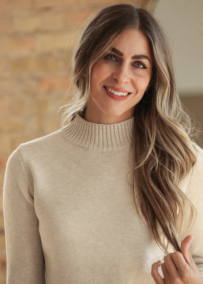 Close-up front view of cream mock neck sweater showing ribbed neckline