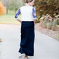 Woman wearing a raglan baseball style top. The shirt is gray with contrasting navy and pink floral sleeves.