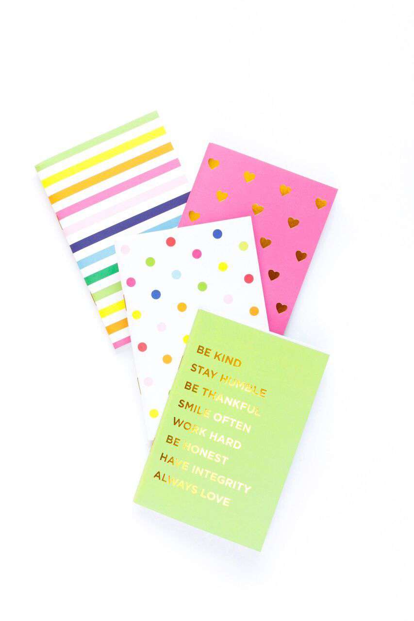 four bright mini notebooks with inspirational text, polka dots and stripes