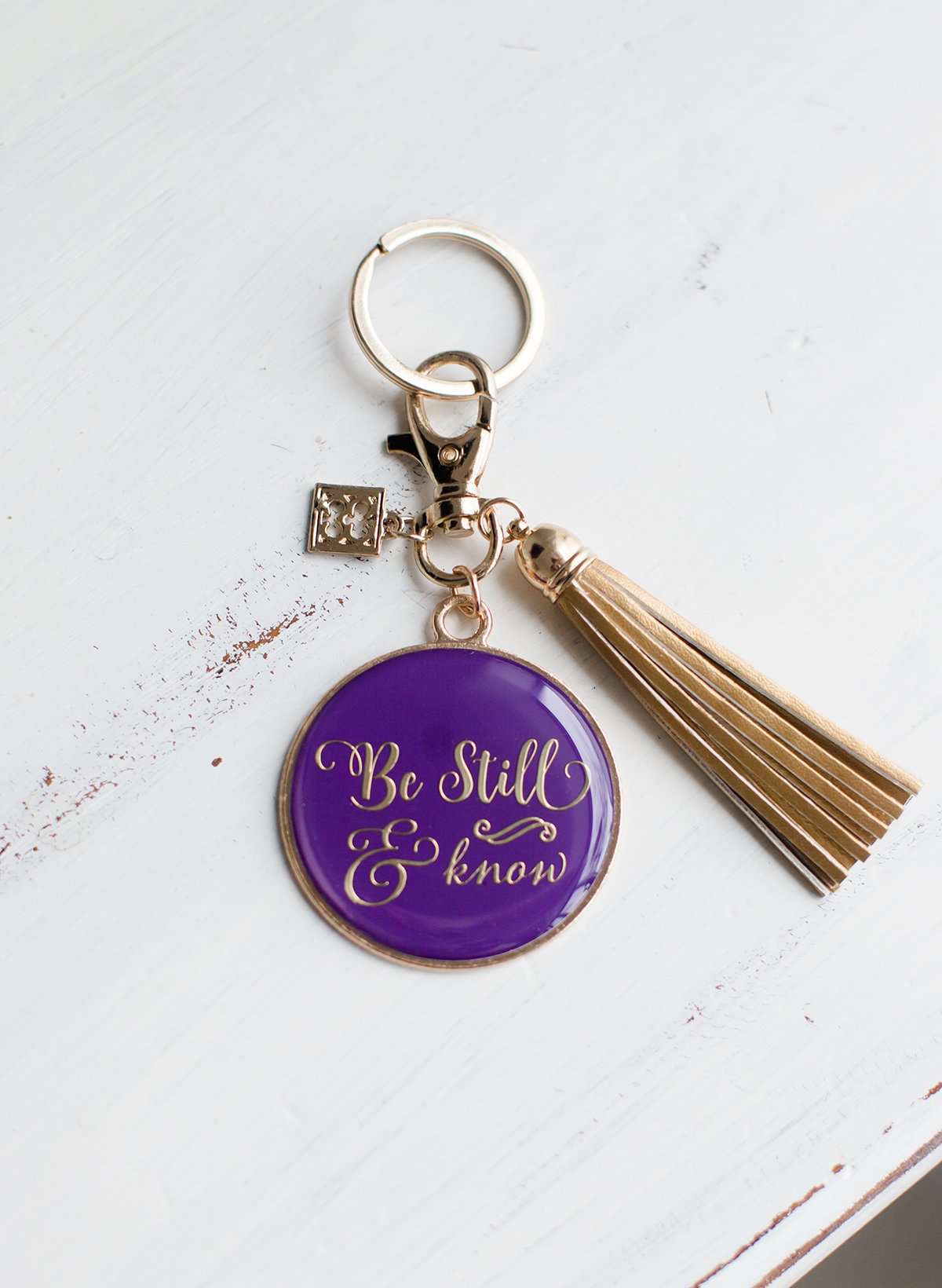 Be still and know purple keychain with gold tassel.