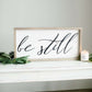 Wood Frame Signboard with the words, "Be Still" written on it in script font.