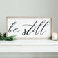 Wood Frame Signboard with the words, "Be Still" written on it in script font.