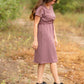 This is a Cinch Waist Athletic midi dress in a purpley taupe color that has a mesh detail and large side pockets. 