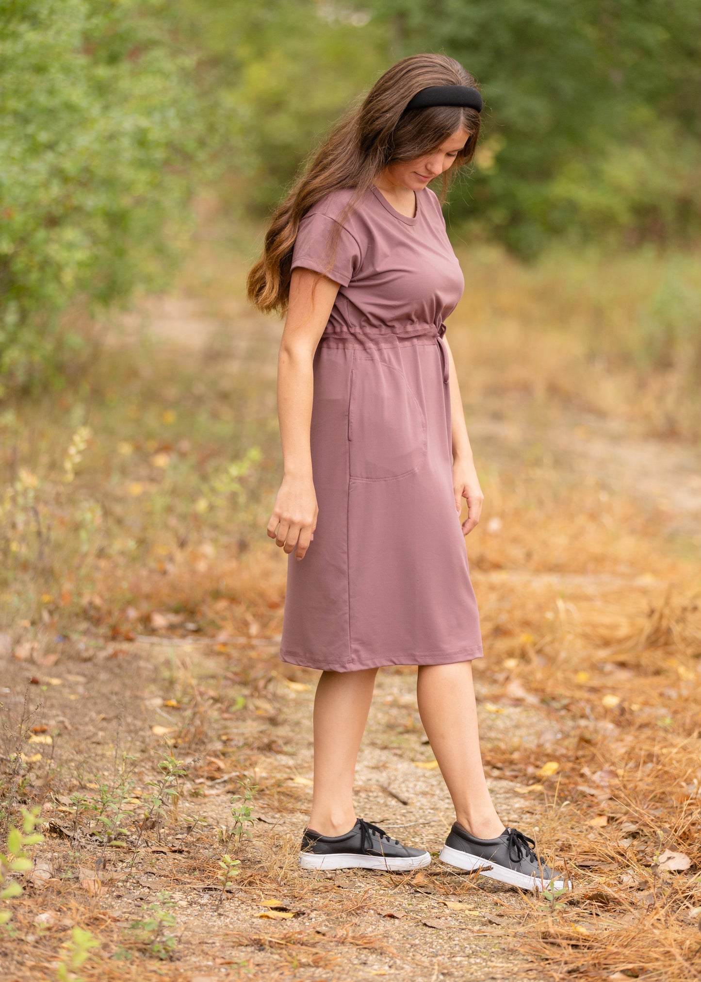 This is a Cinch Waist Athletic midi dress in a purpley taupe color that has a mesh detail and large side pockets. 