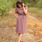 This is a Cinch Waist Athletic midi dress in a purpley taupe color that has a mesh detail and large side pockets. 