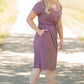 This is a Cinch Waist Athletic midi dress in a purpley taupe color that has a mesh detail and large side pockets. 
