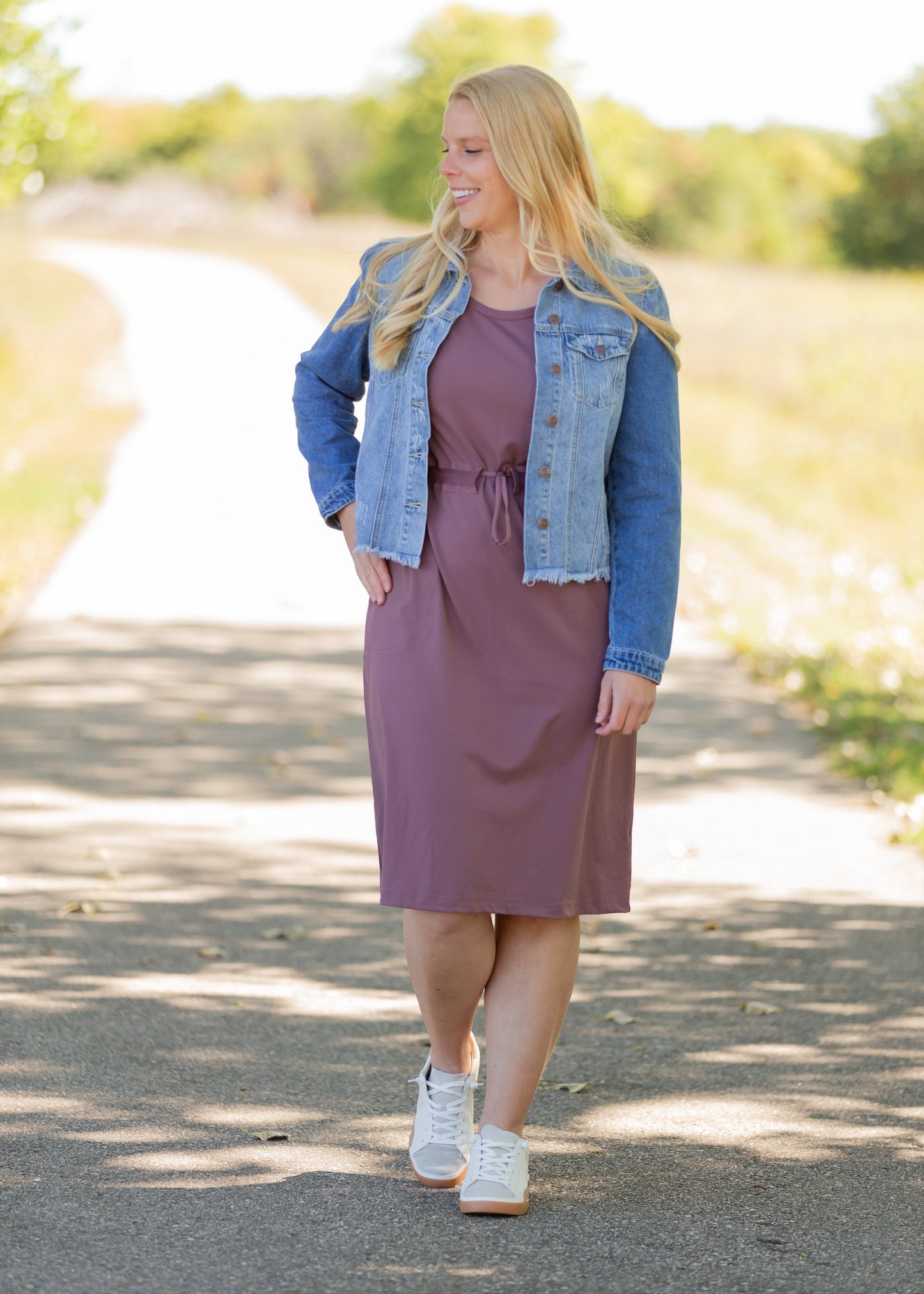 This is a Cinch Waist Athletic midi dress in a purpley taupe color that has a mesh detail and large side pockets. 