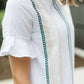 Modest white belle-sleeve top with Earthy colored embroidery down the front.
