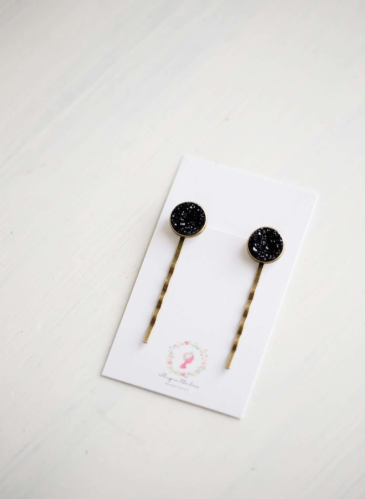 Set of two black druzy bobby pins on a gold post.