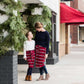 Woman wearing a modest mustard and burgandy striped midi skirt. This skirt has a fabric belt that is removable and is also mommy and me styled. This skirt is paired with tights and boots.