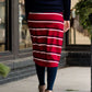 Woman wearing a modest mustard and burgandy striped midi skirt. This skirt has a fabric belt that is removable and is also mommy and me styled. This skirt is paired with tights and boots.