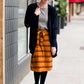 Woman wearing a modest mustard and burgandy striped midi skirt. This skirt has a fabric belt that is removable and is also mommy and me styled. This skirt is paired with tights and boots.
