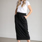A black midi skirt with a drawstring waist, ribbed hem, pockets, and bottom side zipper.