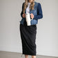 A black midi skirt with a drawstring waist, ribbed hem, pockets, and bottom side zipper.