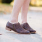 Women's braided ankle bootie in black or brown. These have a stacked heel and feature a size zipper closure.