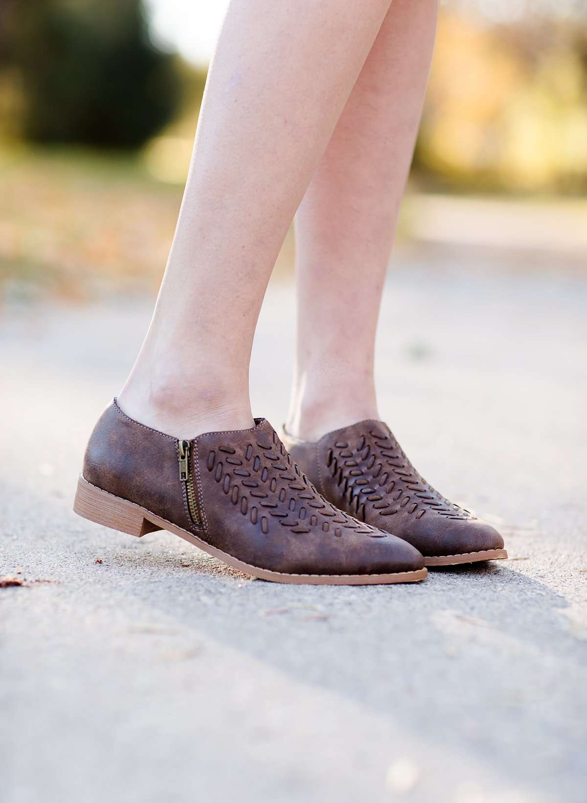 Women's braided ankle bootie in black or brown. These have a stacked heel and feature a size zipper closure.