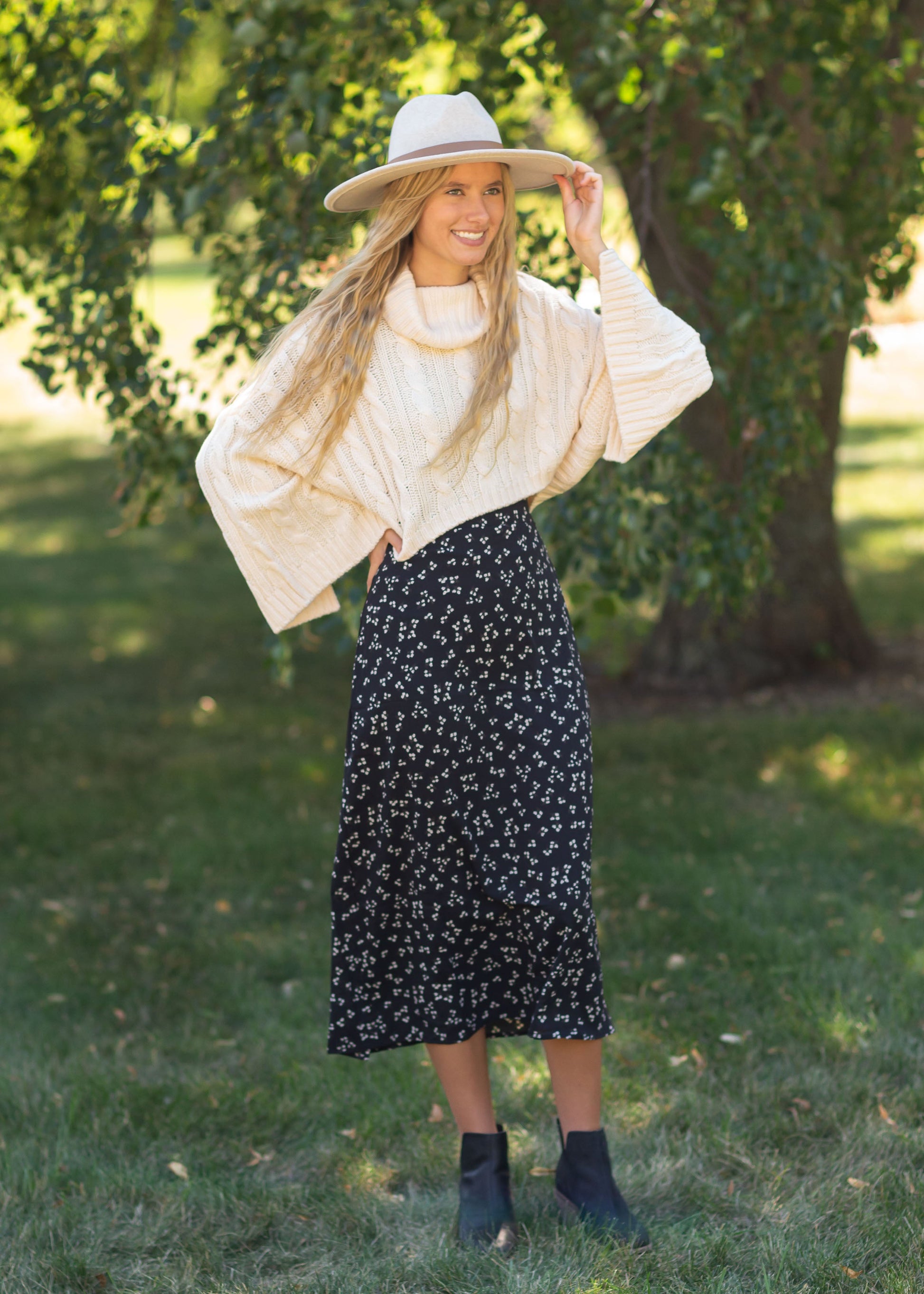 The Braylyn is an Inherit Design that is an a-line midi skirt that is black with white florals with a stretch waist and is so cute.