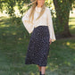 The Braylyn is an Inherit Design that is an a-line midi skirt that is black with white florals with a stretch waist and is so cute.