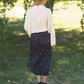 The Braylyn is an Inherit Design that is an a-line midi skirt that is black with white florals with a stretch waist and is so cute.