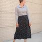 The Braylyn is an Inherit Design that is an a-line midi skirt that is black with white florals with a stretch waist and is so cute.