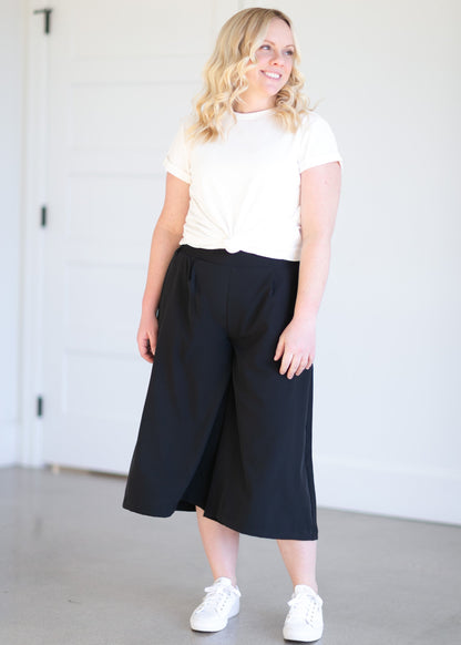 These solid black gauchos are made from a breathable material, with a thick stretchy waistband, pleats at the front, side pockets, and wide legs.