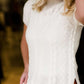This is a mock neck cable knit short sleeve sweater in ivory.