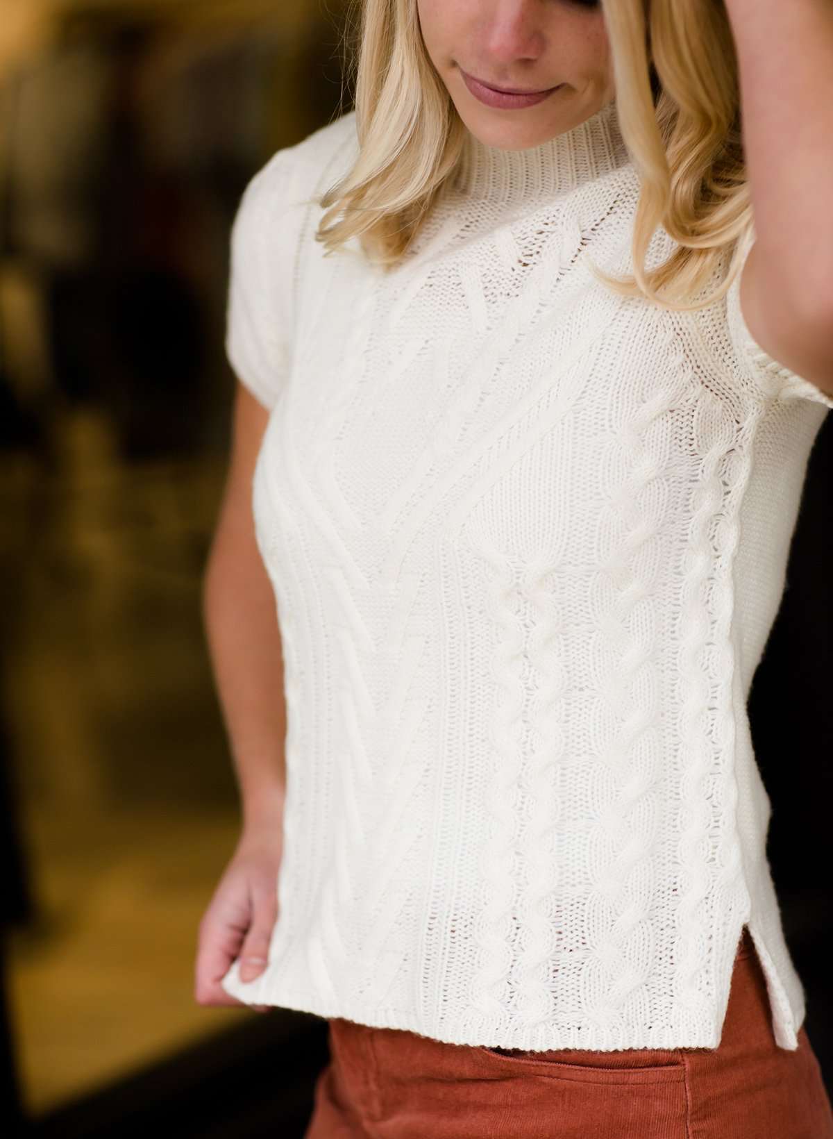 This is a mock neck cable knit short sleeve sweater in ivory.