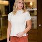 This is a mock neck cable knit short sleeve sweater in ivory.