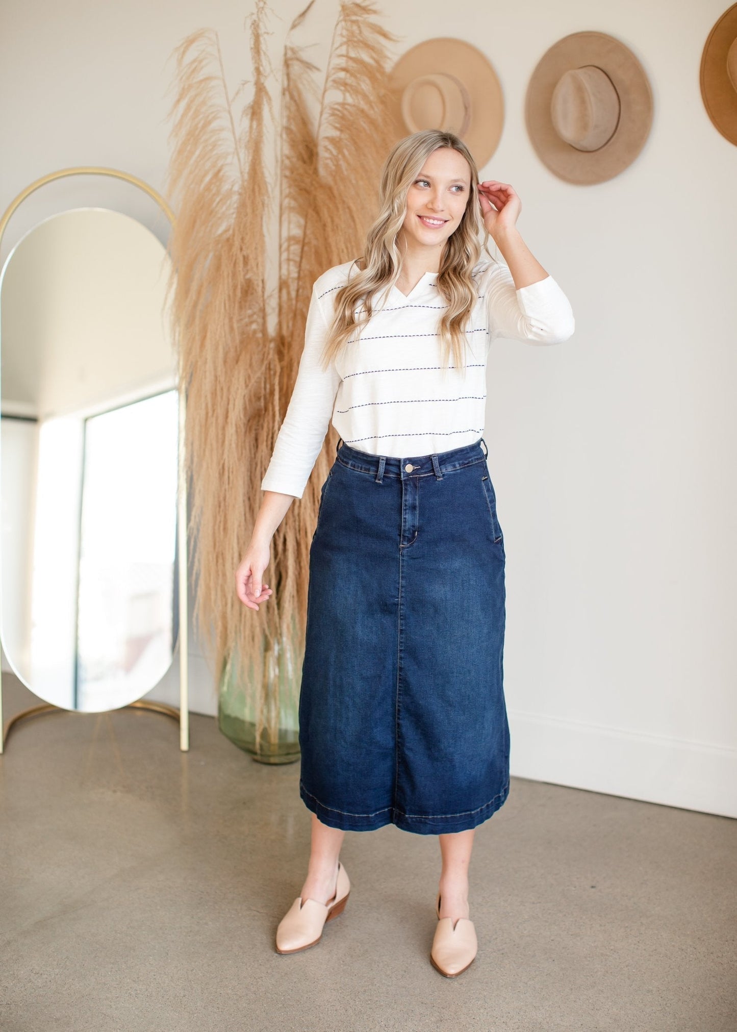 The caren skirt is an inherit design with functioning side pockets and is a slight a-line denim skirt. It has matte gold buttons on the back for added detail.