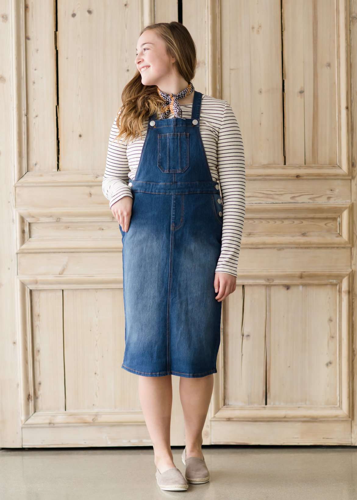 woman in a modest denim overall jumper dress