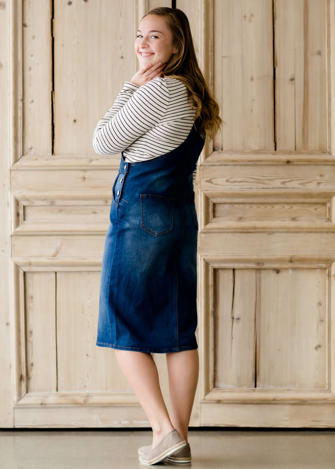 woman in a modest denim overall jumper dress