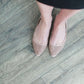 Blush or taupe casually detailed and patterned flat shoe with pointed toe.