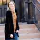 Young girl wearing a black long chenille sweater with front pockets and a cozy fit