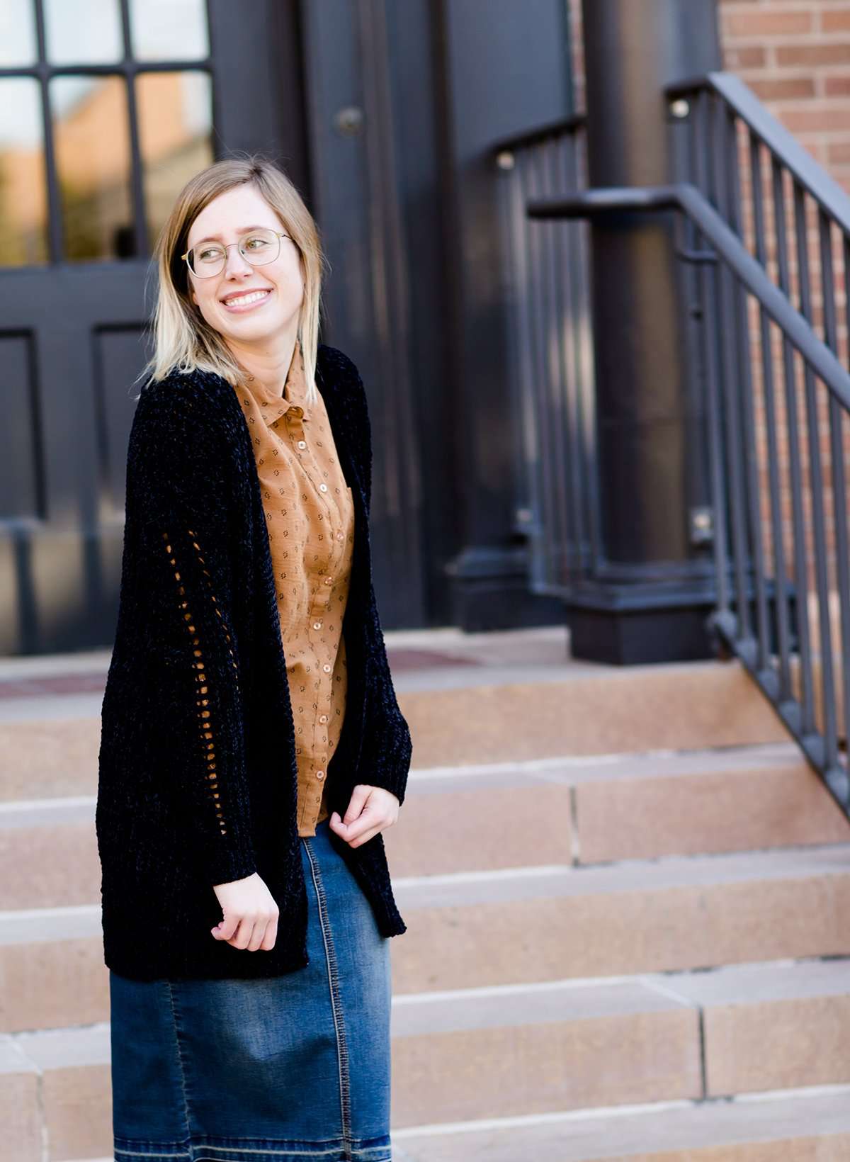 Young girl wearing a black long chenille sweater with front pockets and a cozy fit