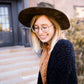Young girl wearing a black long chenille sweater with front pockets and a cozy fit