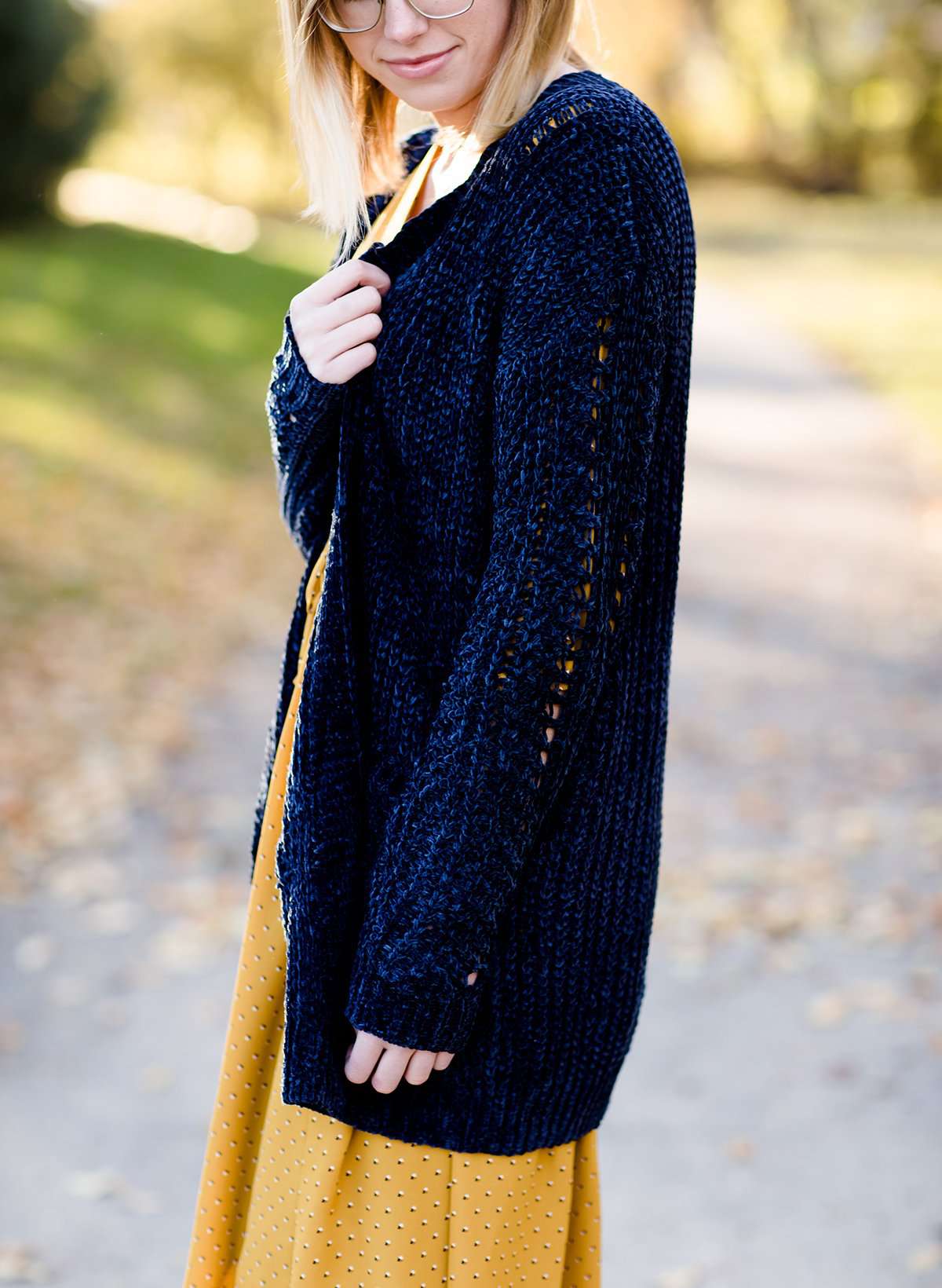 Young girl wearing a navy long chenille sweater with front pockets and a cozy fit