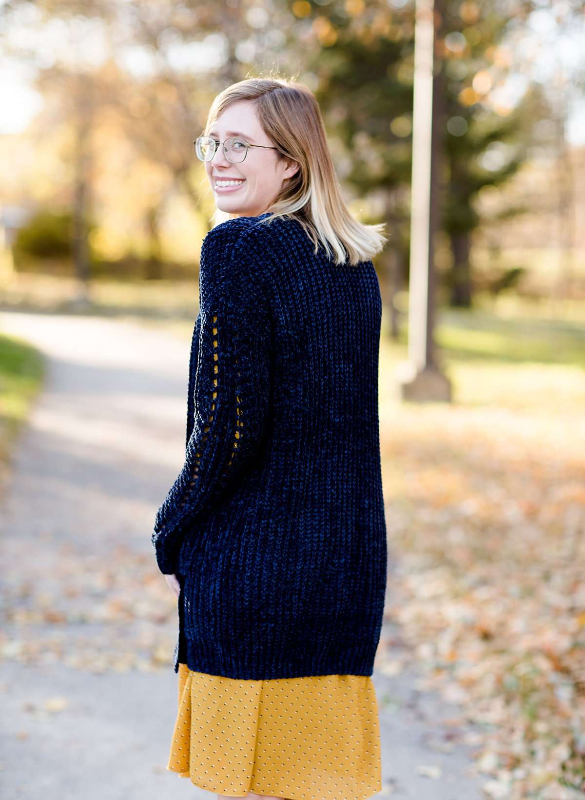 Young girl wearing a navy long chenille sweater with front pockets and a cozy fit