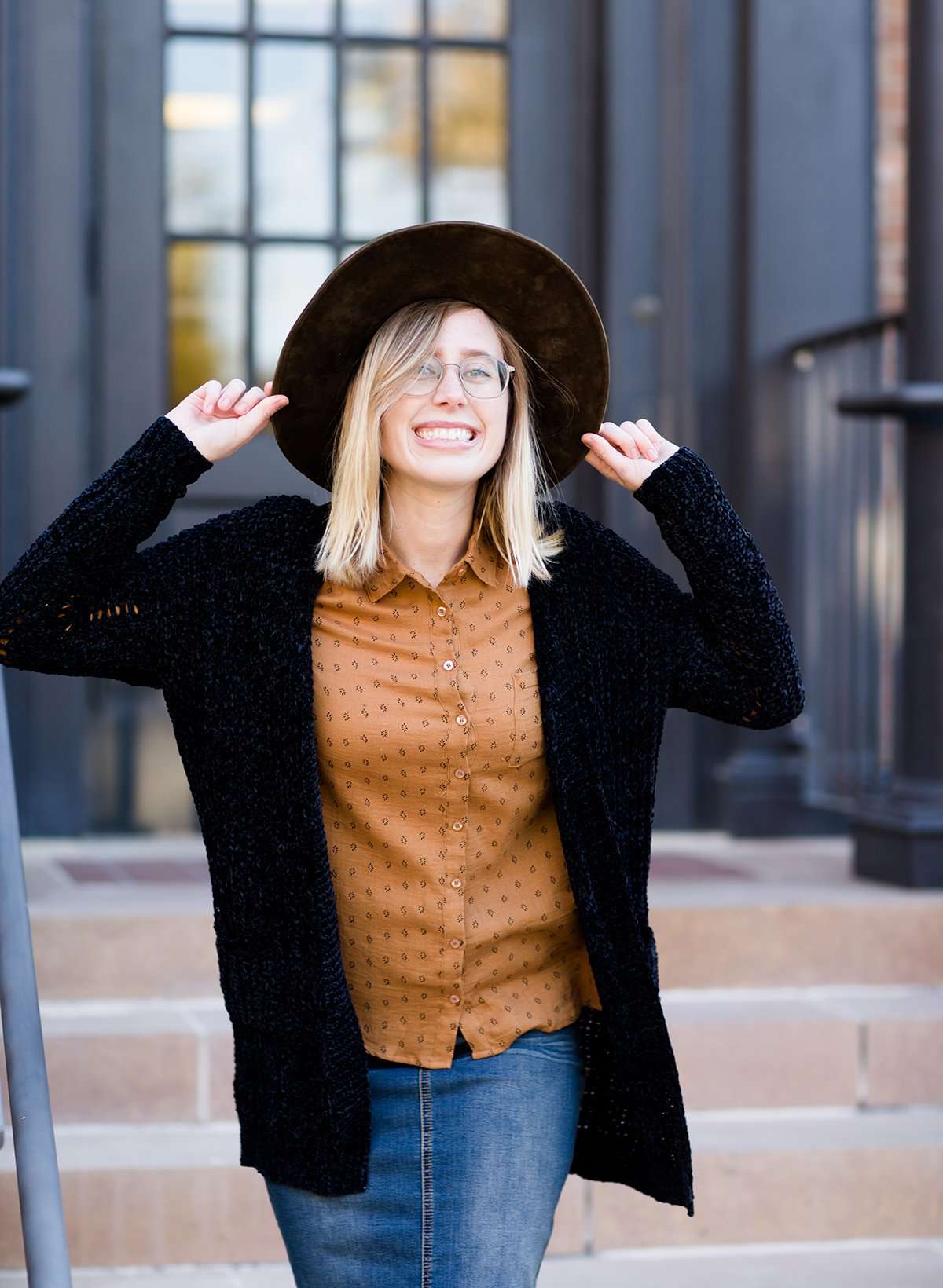 Young girl wearing a black long chenille sweater with front pockets and a cozy fit