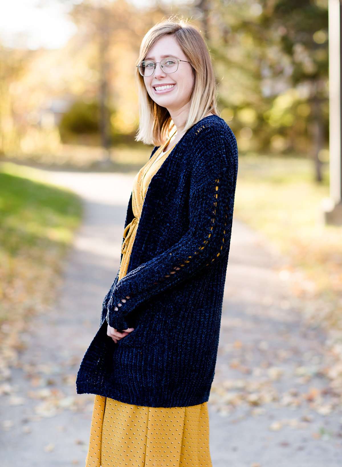 Young girl wearing a navy long chenille sweater with front pockets and a cozy fit