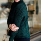 Woman wearing a dark green chenille turtle neck paired with a modest black midi skirt standing outside of Inherit Clothing Company