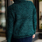 Woman wearing a dark green chenille turtle neck paired with a modest black midi skirt standing outside of Inherit Clothing Company