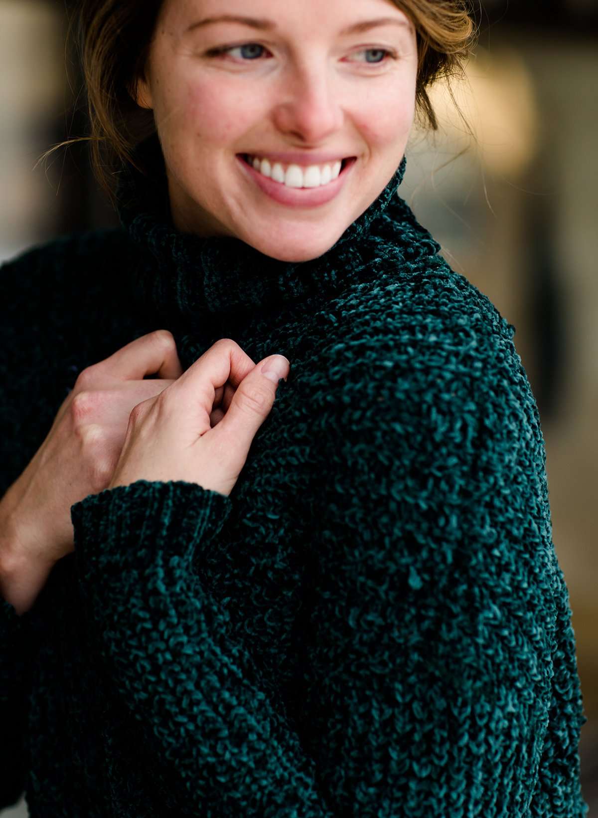 Woman wearing a dark green chenille turtle neck paired with a modest black midi skirt standing outside of Inherit Clothing Company