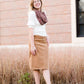 Woman wearing a chenille style snood scarf. This cowl like scarf comes in cream or taupe.