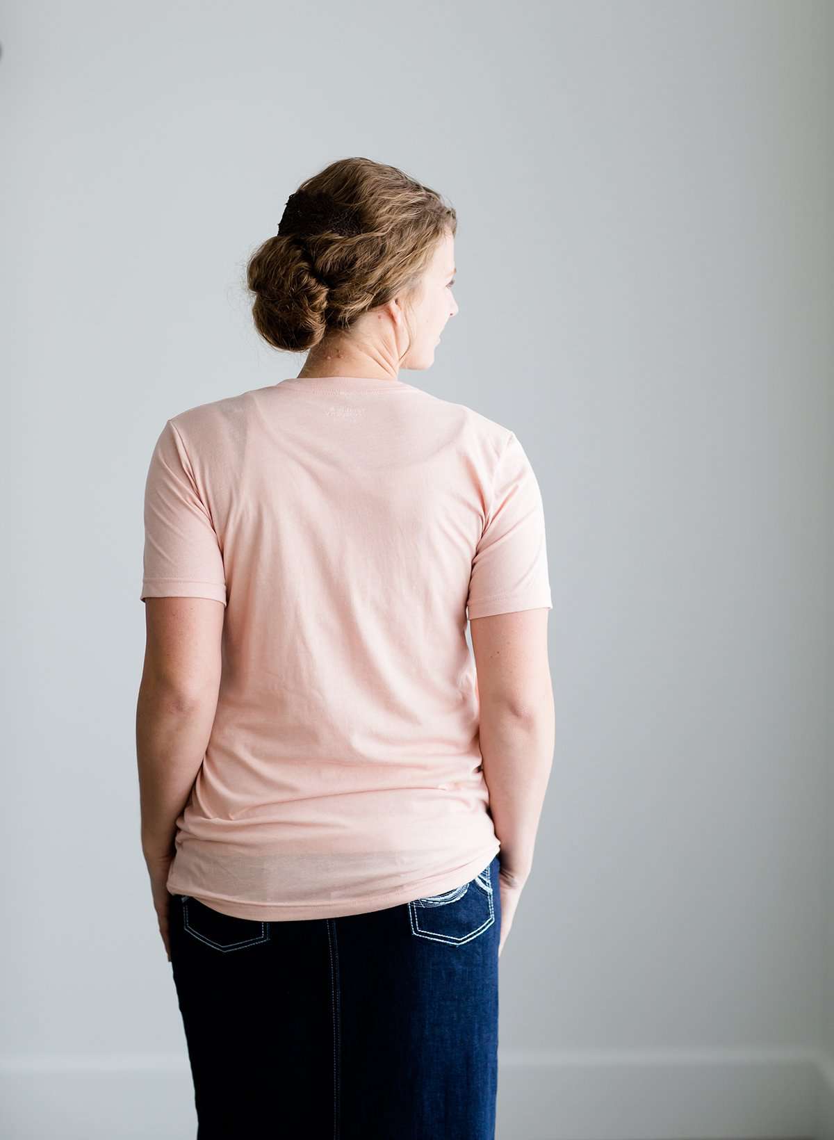 Woman wearing a blush colored modest graphic tee that says, Today I Choose Joy. This tee is a triblend of material and is paired with a long denim modest skirt and chambray top.