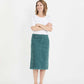 Woman wearing a below the knee corduroy skirt. This skirt is a fin corduroy with a gold button snap, no slit and no back pockets. It comes in burgundy, teal, burnt orange and dark khaki.