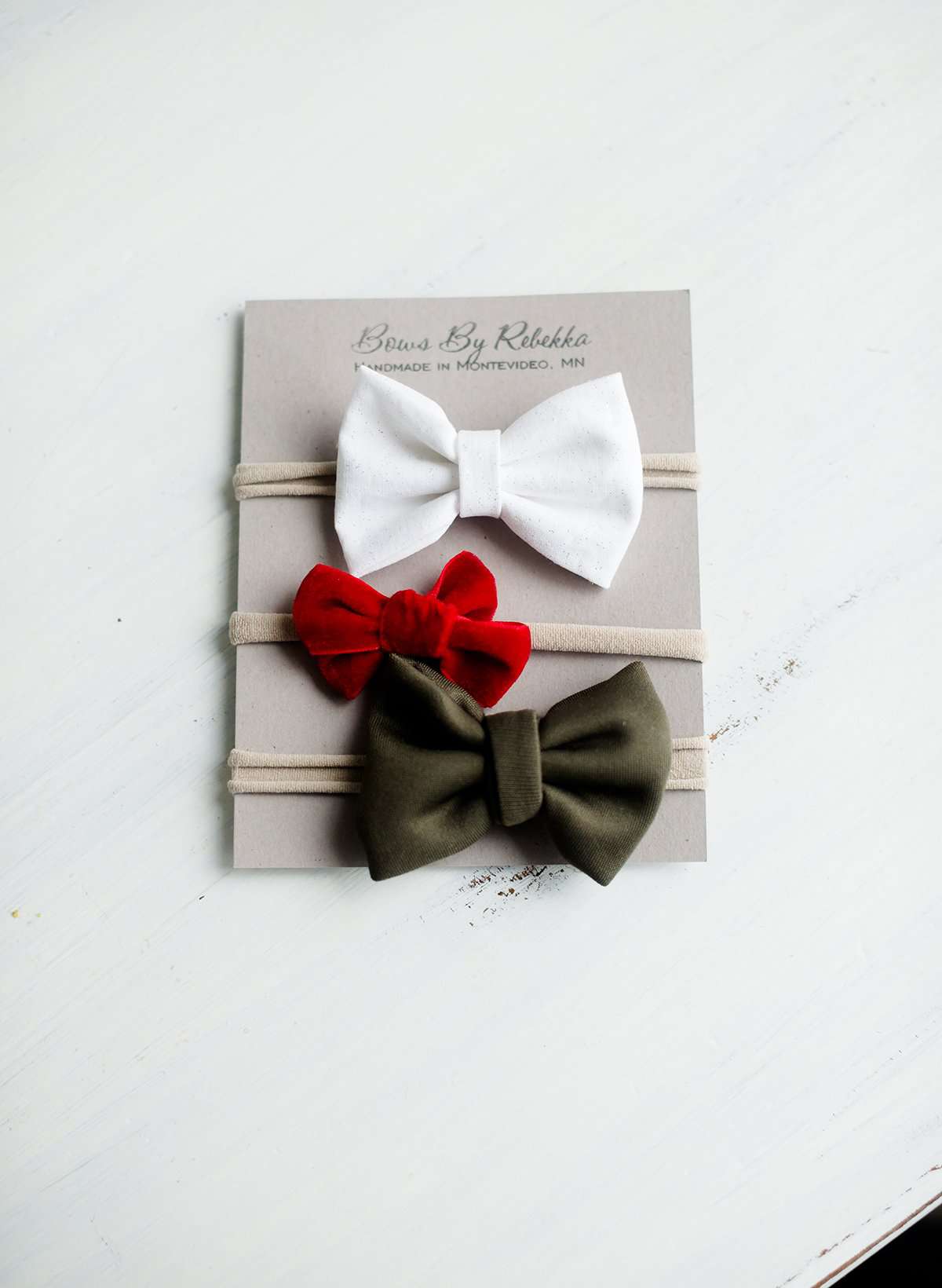 Little girls hair bow set of three. This shows a white, green and red velvet headband on a nylon band.