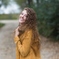 Woman wearing a mustard corduroy button down jacket with pockets.